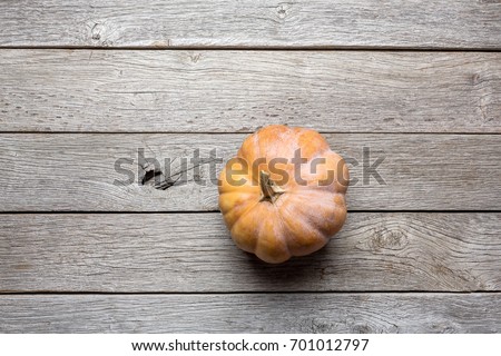 Orange pumpkin on rustic wood background with copy space. Thanksgiving and halloween concept, top view