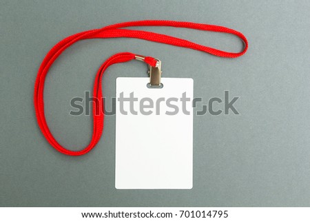 Empty layout layout isolated on black. A common blank label name tag hanging on the neck with a red thread on a gray background.