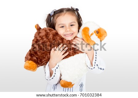 Happy little girl playing with her sheep toy - celebrating Eid ul Adha - Happy Sacrifice Feast Royalty-Free Stock Photo #701032384