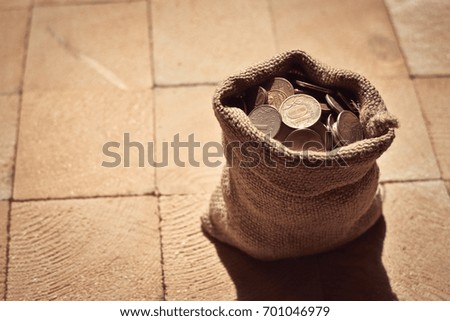 coins in a sack on a wooden surface