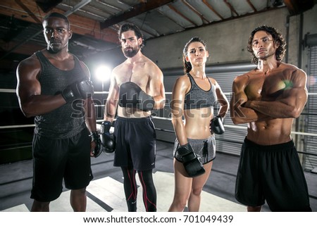 Mixed race group of multiethnic fitness trainers standing together looking intimidating and confident Royalty-Free Stock Photo #701049439