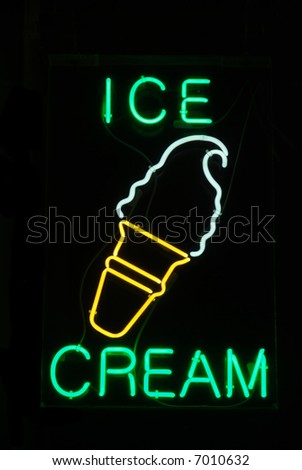 Illuminated ice cream cone neon sign on black