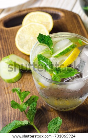 Cold lemonade with lemon, mint and cucumber in glass.