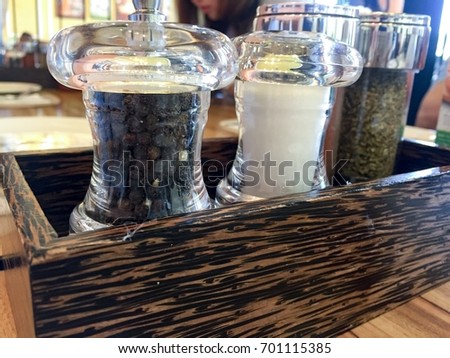 Set of ingredients on wooden table in pizza restaurant. Basic seasoning set of pizza and pasta that can make the dish more delicious. Pepper, salt, and oregano are the seasoning set.