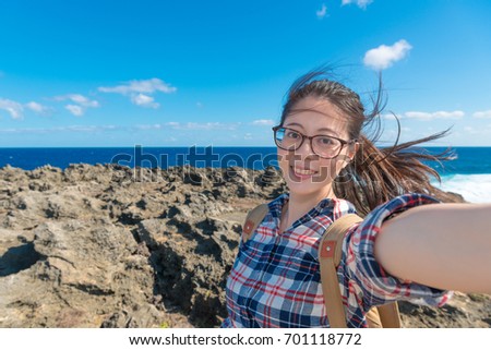 cheerful pretty female traveler selfie when she travel in national park and viewing beautiful blue ocean landscape during summer holiday.