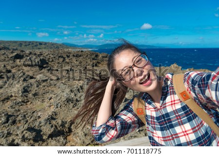 joyful beauty girl backpacker going to ocean island travel and enjoying local landscape with comfortable wind taking picture selfie.