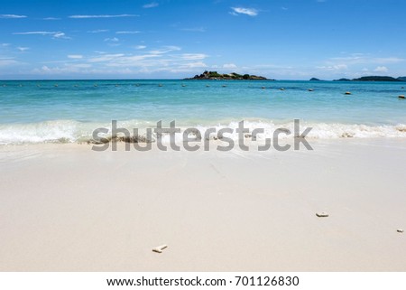 splash of wave water with white sand and blue sea in sunshine day