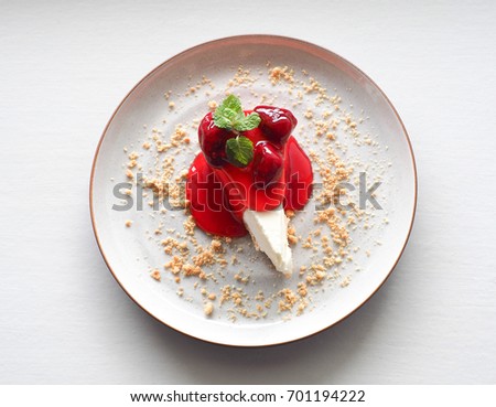 closeup top view of strawberry cheesecake with mint leaves on white plate and white table Royalty-Free Stock Photo #701194222