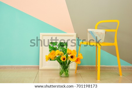 Comfortable yellow chair and decorative elements near wall in modern room