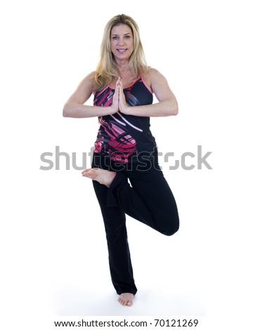 A yoga instructor demonstrating balance and flexibility in a standing pose.Taken on a white backdrop.