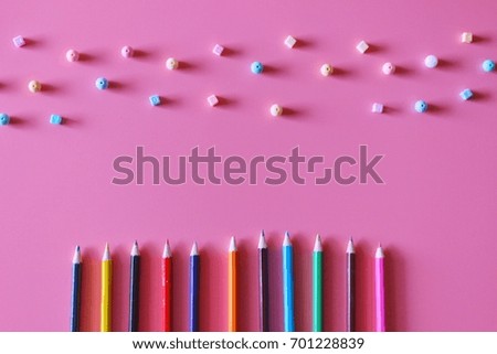 Colour pencil and bead on Pink pastel background with copy space