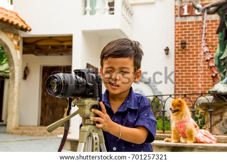 photographer kid holding a instant camera outdoors. He very happy when he take a photo.