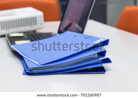 Blurred File folder with Documents, Notebook and Projector background on white table in meeting room - concept business 