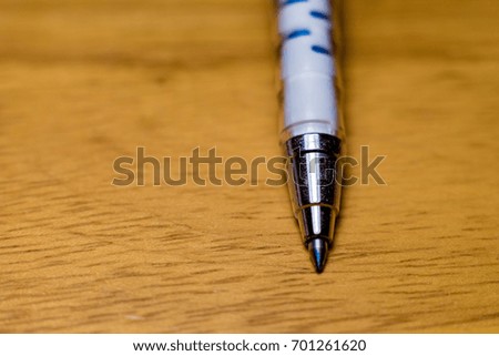 Ball Business pen on wood table ,focus on the pen tip, Concept for Education, Business or Creative thinking.