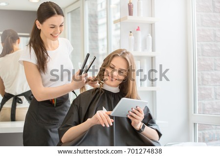  Young women sitting in beauty hair salon style Royalty-Free Stock Photo #701274838