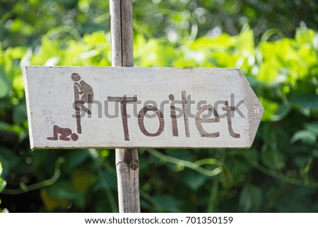wooden sign Toilet with nature background. subject is blurred. 