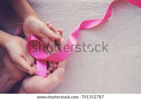 Adult and child hands holding pink ribbons, Breast cancer awareness, abdominal cancer awareness and October Pink day background, world cancer day Royalty-Free Stock Photo #701352787