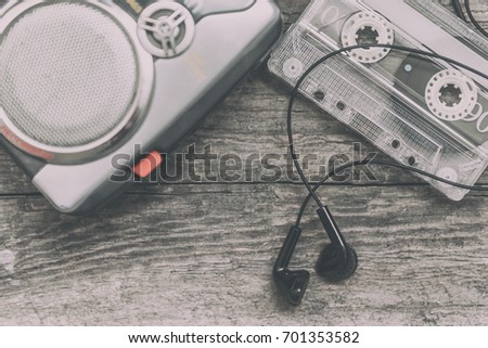 Vintage walkman cassette player with earbuds and tape cassette.Retro style toned image. Selective focus
