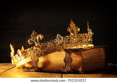 low key image of beautiful queen/king crown on old book. vintage filtered. fantasy medieval period