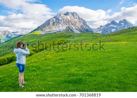 The girl photographer shoots the top of the mountain Komovi. Montenegro.