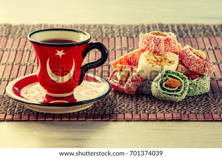 Cup of coffee on saucer and Turkish delight lying on bamboo cloth