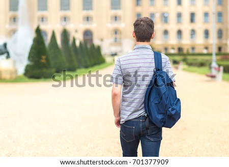 Young student walking to the university. Back view photo