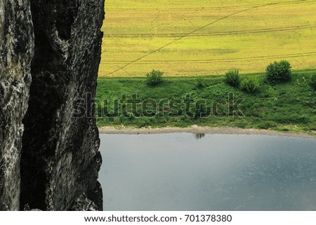 A picture from the Saxon Switzerland in Germany. A detail view of the meadow, rocks and river down below. 