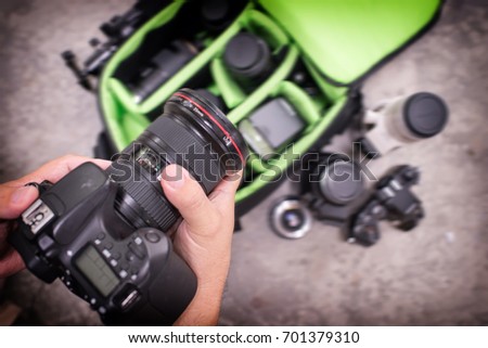 Photographer pack his camera and lenses to bagpack. Bag appliances for photography. Royalty-Free Stock Photo #701379310
