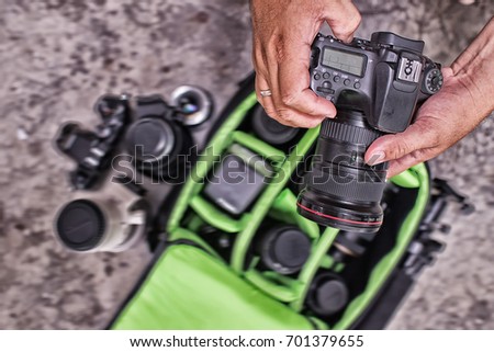 Photographer pack his camera and lenses to bag-pack. Bag appliances for photography top view.