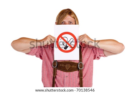 Bavarian man in lederhose holds no-smoking-rule sign in front of face. Isolated on white background.