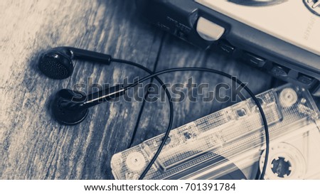 Vintage cassette player with earbuds and tape cassette.Retro style toned image. Selective focus