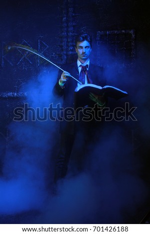 handsome mystic writer standing on black background in the smoke