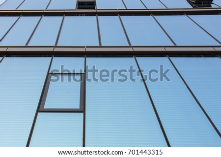 Geometrical texture of shining office windows with sky reflection