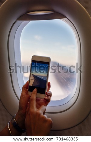 Close up of woman hands taking photo on plane. Travel Concept.