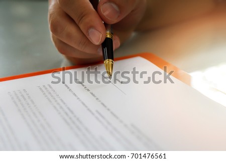 Close up of business man signing contract making a deal, business contract details. Businessman signing an official document