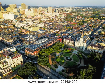 Aerial view of Jackson Square with Saint Louis Cathedral church and surround extant historical buildings from French Quarter and downtown skylines on the left in morning. New Orleans travel background