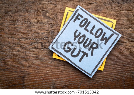 Follow your gut advice or reminder - handwriting on sticky note against rustic wood Royalty-Free Stock Photo #701515342