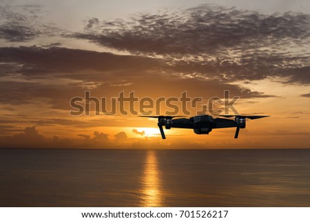 Silhouette drone against the sunset over the ocean