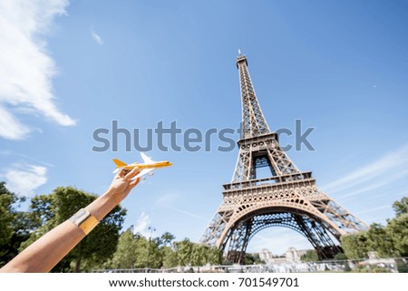 Holding a toy airplane on the Eiffel tower background. Air connection and tourism concept in Paris