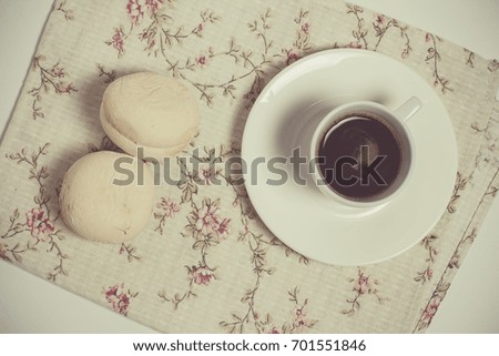 Two marshmallows and a cup of coffee on a beautiful napkin