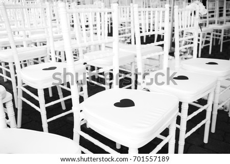 rows of wedding chairs decorated with hearts. black and white picture
