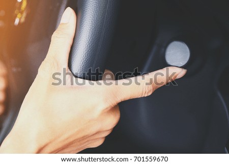 Close up on Hand driving car and turning the signal switch.