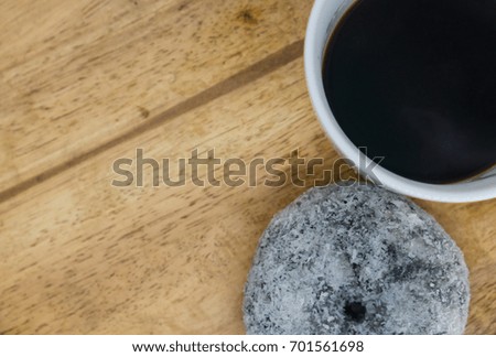 Top view dough nut and black coffee on wooden board