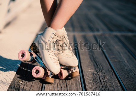 Close up of young woman with roller skating in a sunny day in summer.