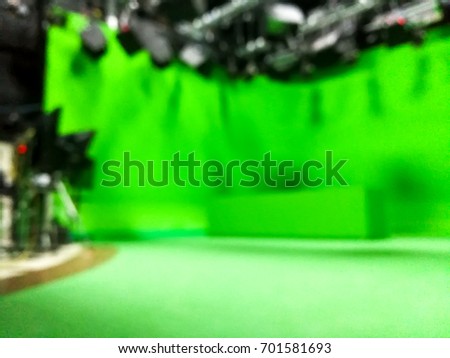 blur image a television presenter in a TV camera in studio a green screen.