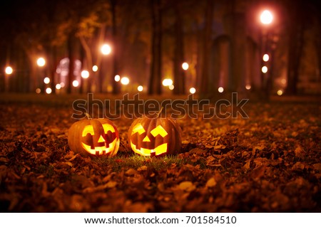 Two Kind Halloween Pumpkins in the park at night Royalty-Free Stock Photo #701584510