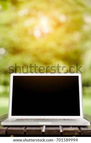 Conceptual work space, Laptop computer with blank screen on table, blurred background. 
