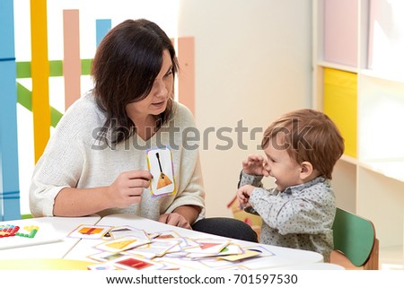 mother or the teacher teaches the child showing the picture Royalty-Free Stock Photo #701597530