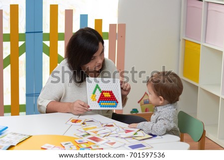 mother or the teacher teaches the child showing the picture