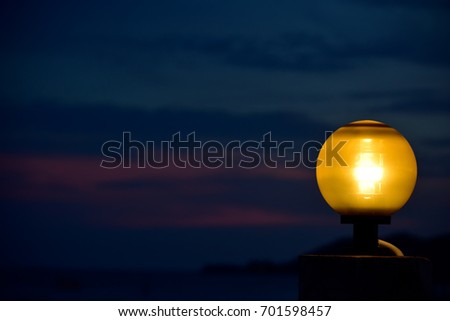 Yellow lamp on background twilight sky .